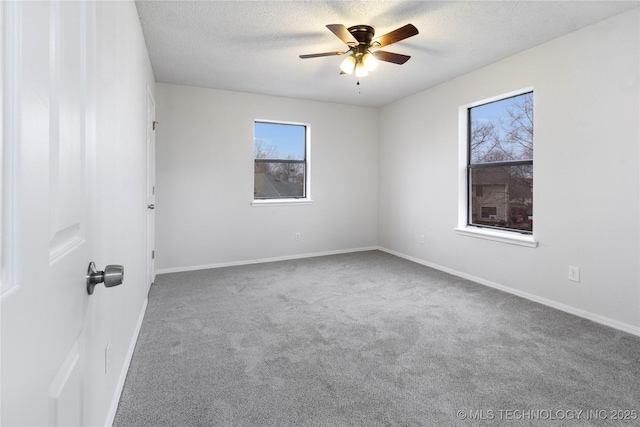 carpeted empty room featuring ceiling fan and a textured ceiling