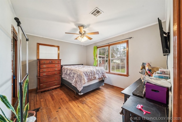 bedroom with crown molding, hardwood / wood-style flooring, and ceiling fan