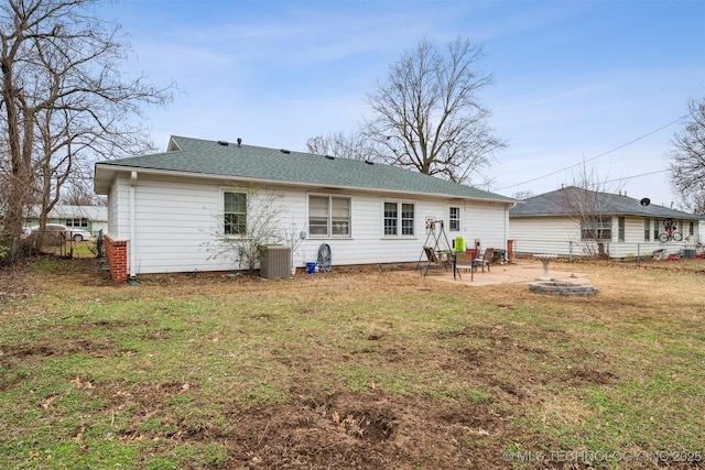 back of house featuring cooling unit, a patio, a yard, and a fire pit