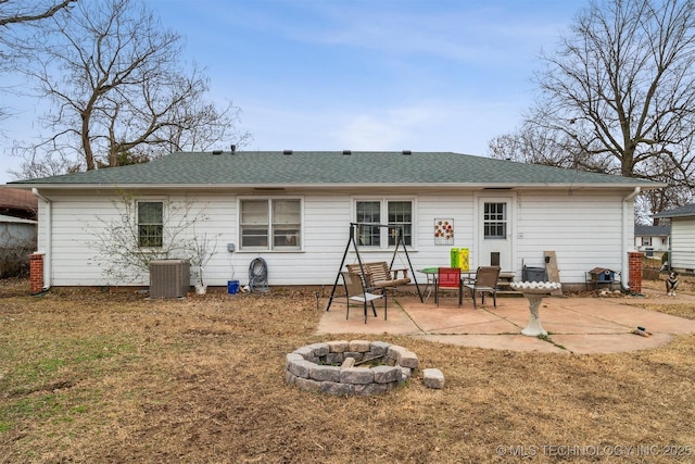 back of house featuring an outdoor fire pit, central AC unit, a patio, and a lawn