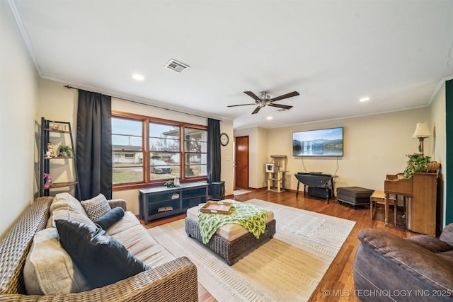 living room featuring hardwood / wood-style flooring, ceiling fan, and ornamental molding