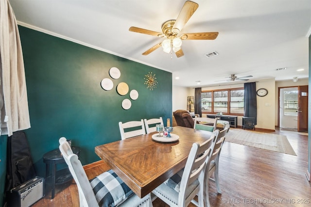 dining room with hardwood / wood-style floors, ornamental molding, and ceiling fan