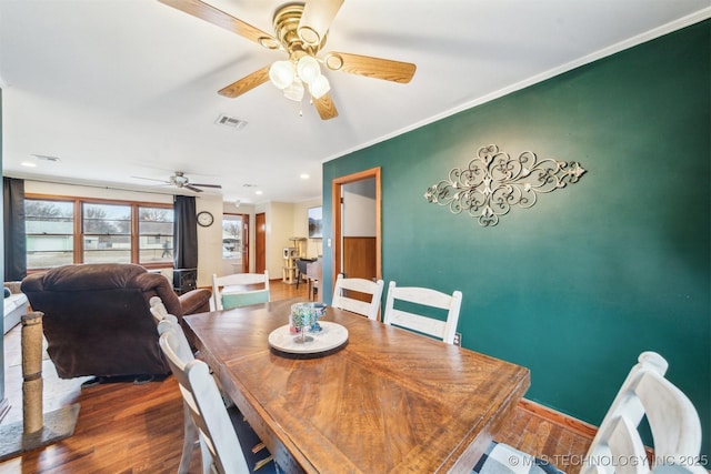 dining room with hardwood / wood-style floors, ornamental molding, and ceiling fan