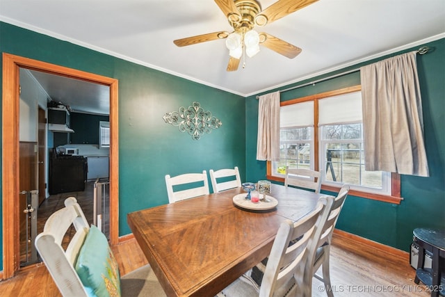 dining room featuring ceiling fan, ornamental molding, and light hardwood / wood-style floors