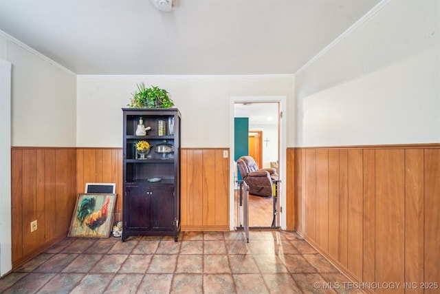 spare room featuring ornamental molding and wooden walls