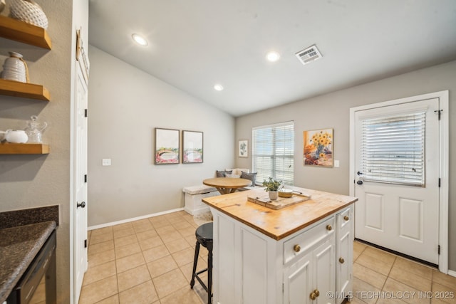 kitchen featuring visible vents, white cabinets, a center island, open shelves, and a kitchen bar