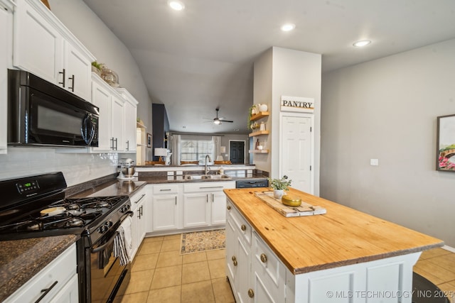 kitchen featuring white cabinets, a kitchen island, a sink, a peninsula, and black appliances