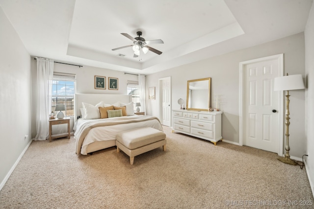 bedroom featuring a ceiling fan, a raised ceiling, light colored carpet, and baseboards