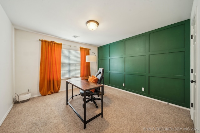 home office featuring light carpet, baseboards, visible vents, and a decorative wall