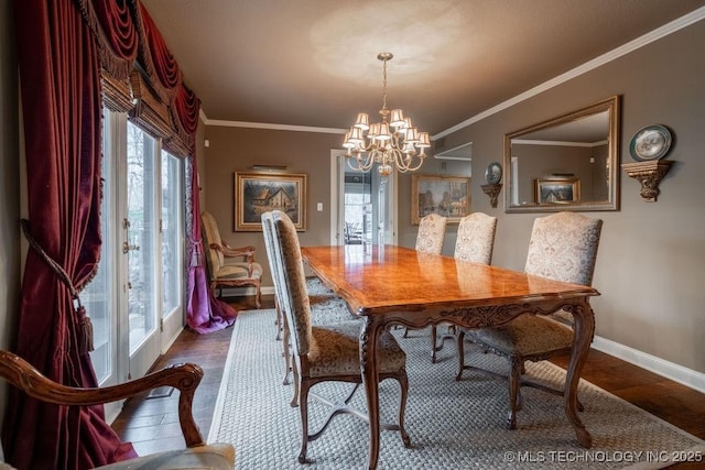 dining space with crown molding, baseboards, an inviting chandelier, and wood finished floors