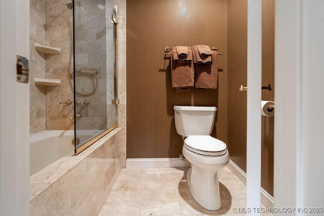bathroom featuring tiled shower / bath combo, baseboards, and toilet