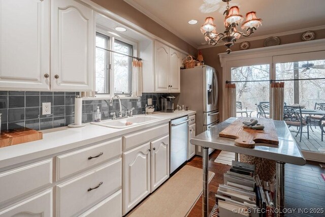 kitchen with a sink, decorative backsplash, white cabinetry, and dishwasher