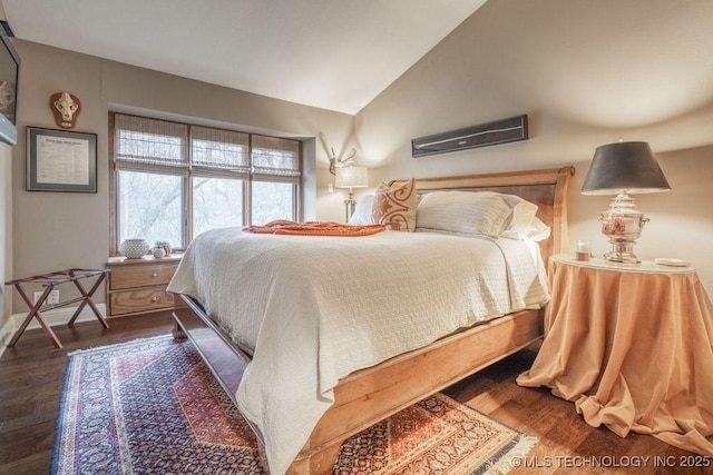 bedroom with baseboards, wood finished floors, and lofted ceiling