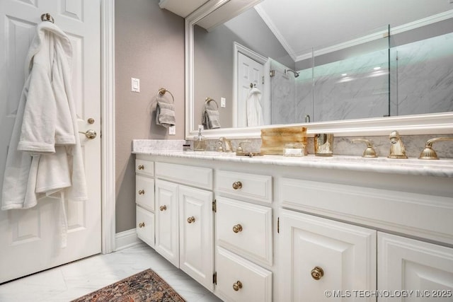 bathroom featuring a sink, ornamental molding, double vanity, a marble finish shower, and marble finish floor