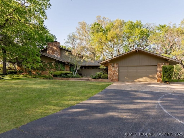 mid-century home featuring a chimney, an attached garage, a front lawn, and concrete driveway