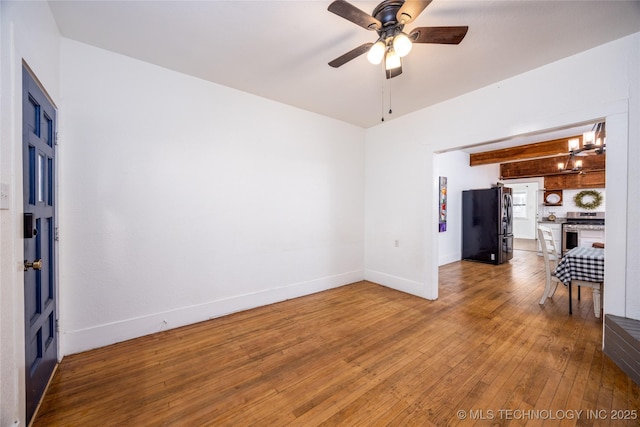 unfurnished living room with hardwood / wood-style flooring, ceiling fan, and beam ceiling