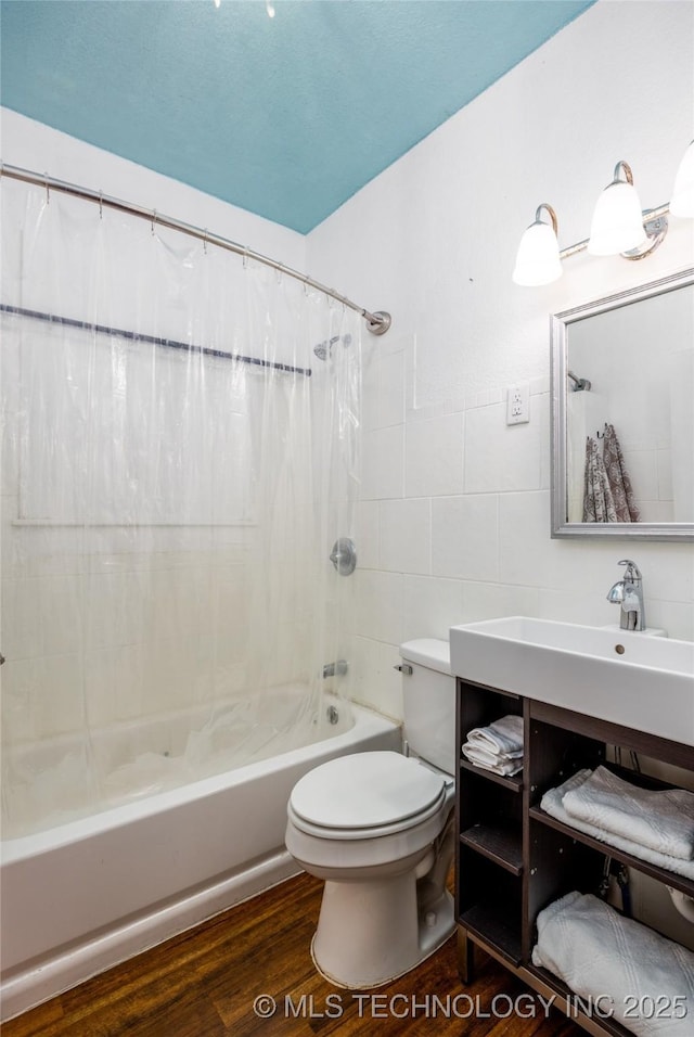 full bathroom with shower / tub combo with curtain, toilet, sink, tile walls, and hardwood / wood-style flooring