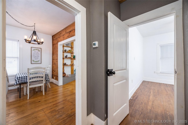 hall featuring hardwood / wood-style floors and a notable chandelier