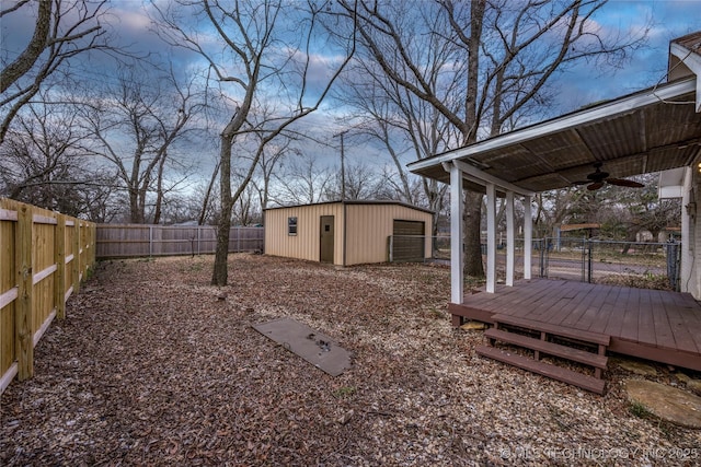 view of yard featuring ceiling fan, an outdoor structure, and a deck