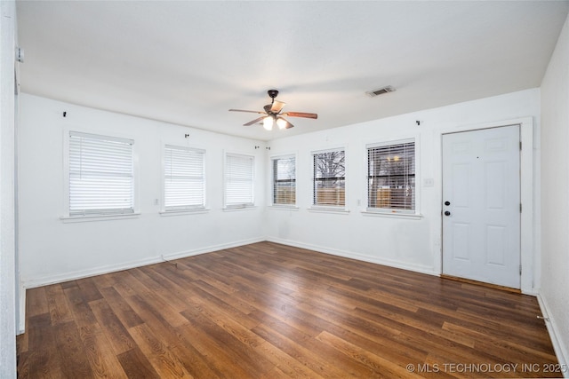 unfurnished room featuring dark wood-type flooring and ceiling fan