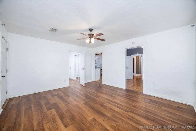 spare room with dark wood-type flooring and ceiling fan