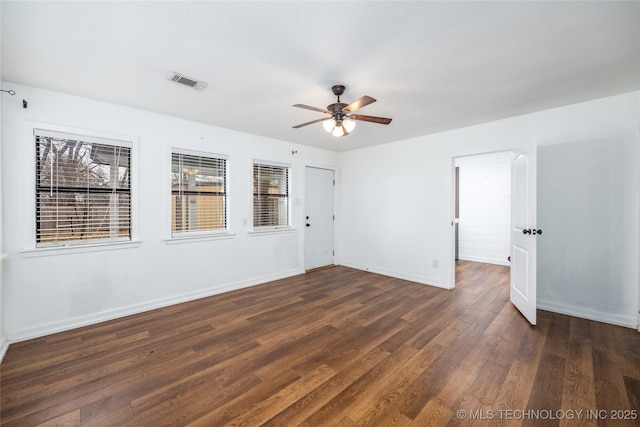 empty room with dark wood-type flooring and ceiling fan