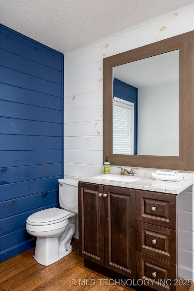 bathroom featuring vanity, hardwood / wood-style floors, a textured ceiling, and toilet