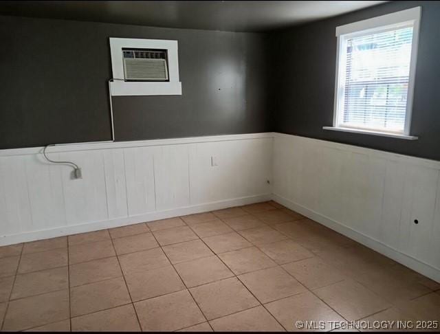 tiled spare room with a wall unit AC