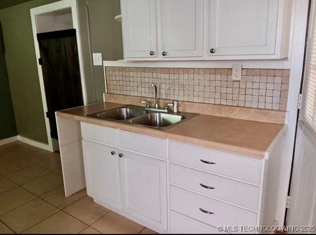 kitchen featuring white cabinetry, sink, and light tile patterned flooring