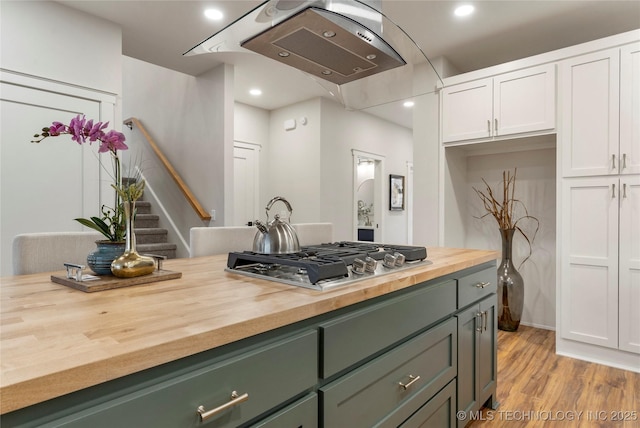kitchen featuring stainless steel gas stovetop, white cabinetry, butcher block countertops, and green cabinets