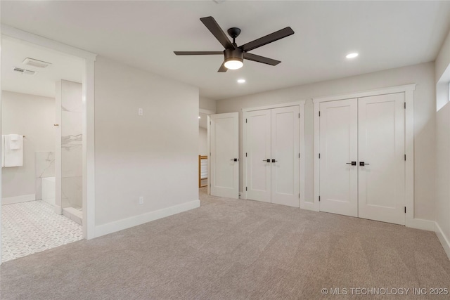 unfurnished bedroom with baseboards, recessed lighting, carpet, and multiple closets