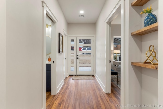 entryway featuring wood finished floors, visible vents, and baseboards