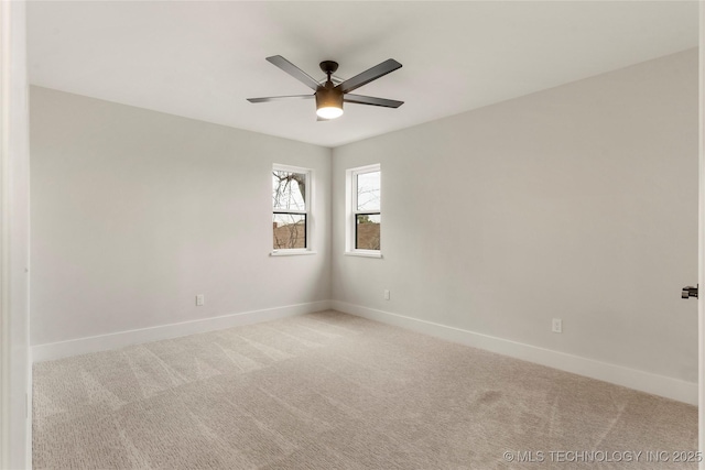 carpeted spare room with baseboards and ceiling fan
