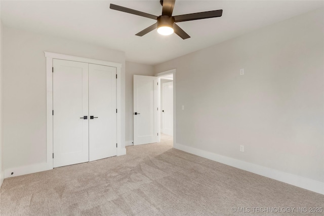 unfurnished bedroom with baseboards, a ceiling fan, a closet, and light colored carpet