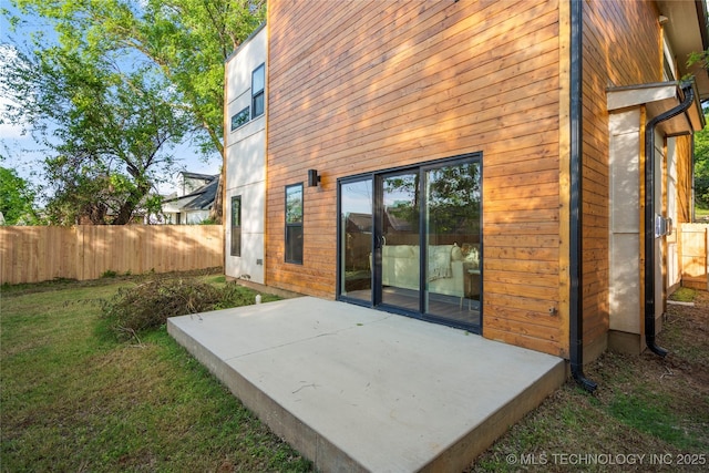 back of house featuring fence private yard, a yard, and a patio area