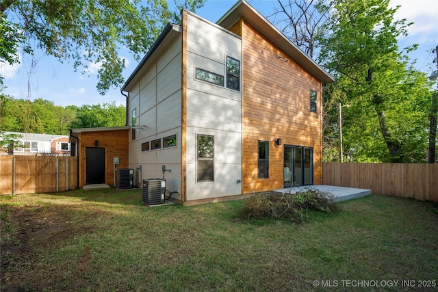 rear view of house with central AC, a yard, a patio, and a fenced backyard