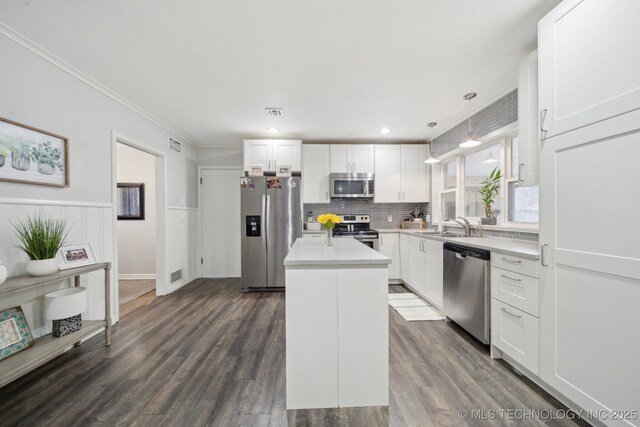 kitchen featuring hanging light fixtures, appliances with stainless steel finishes, a center island, and white cabinets