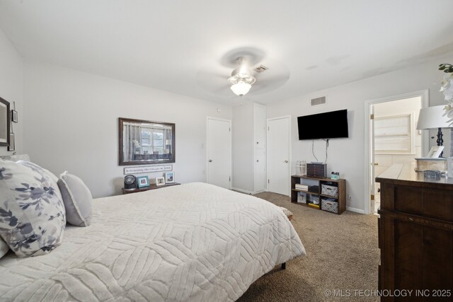 bedroom featuring ceiling fan, ensuite bathroom, and carpet floors