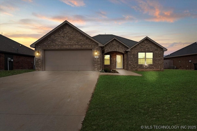 view of front of house featuring a garage, central air condition unit, and a lawn