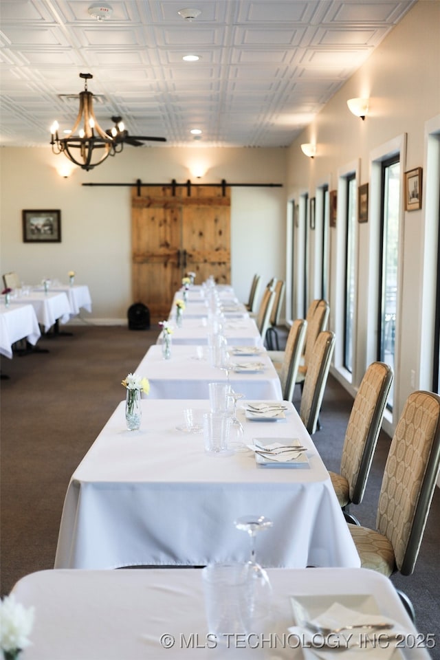 dining area with a barn door and a notable chandelier