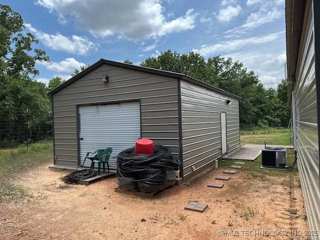 view of outbuilding with central AC and a garage