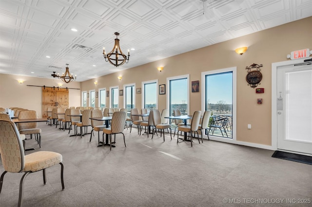 dining space with a barn door and a notable chandelier