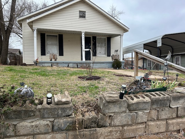 view of front of property with a porch, a carport, and a front lawn