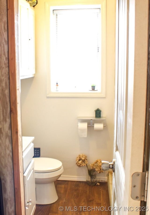 bathroom with hardwood / wood-style flooring, vanity, and toilet