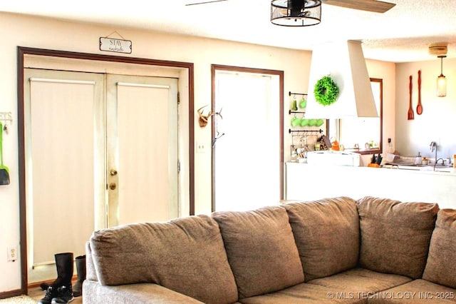 living room featuring ceiling fan, sink, and a textured ceiling