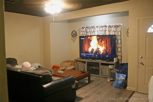 home theater room featuring hardwood / wood-style flooring, ceiling fan, and a fireplace