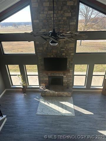 unfurnished living room featuring dark hardwood / wood-style flooring, a towering ceiling, and a large fireplace