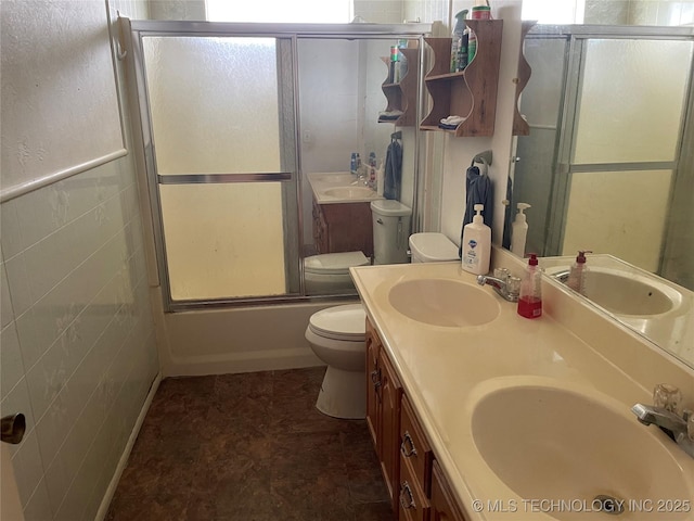 full bathroom featuring tile walls, vanity, enclosed tub / shower combo, and toilet