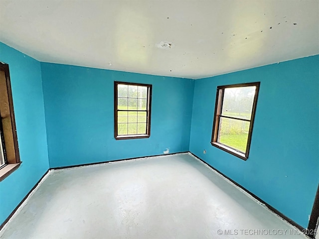 empty room featuring concrete flooring and a wealth of natural light