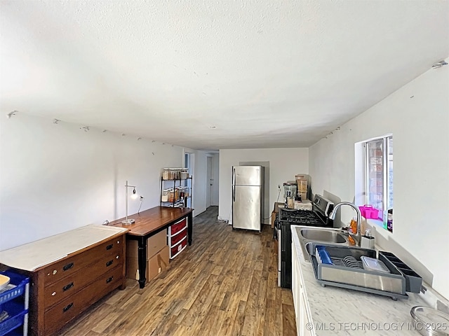 kitchen with dark hardwood / wood-style floors, a textured ceiling, and appliances with stainless steel finishes